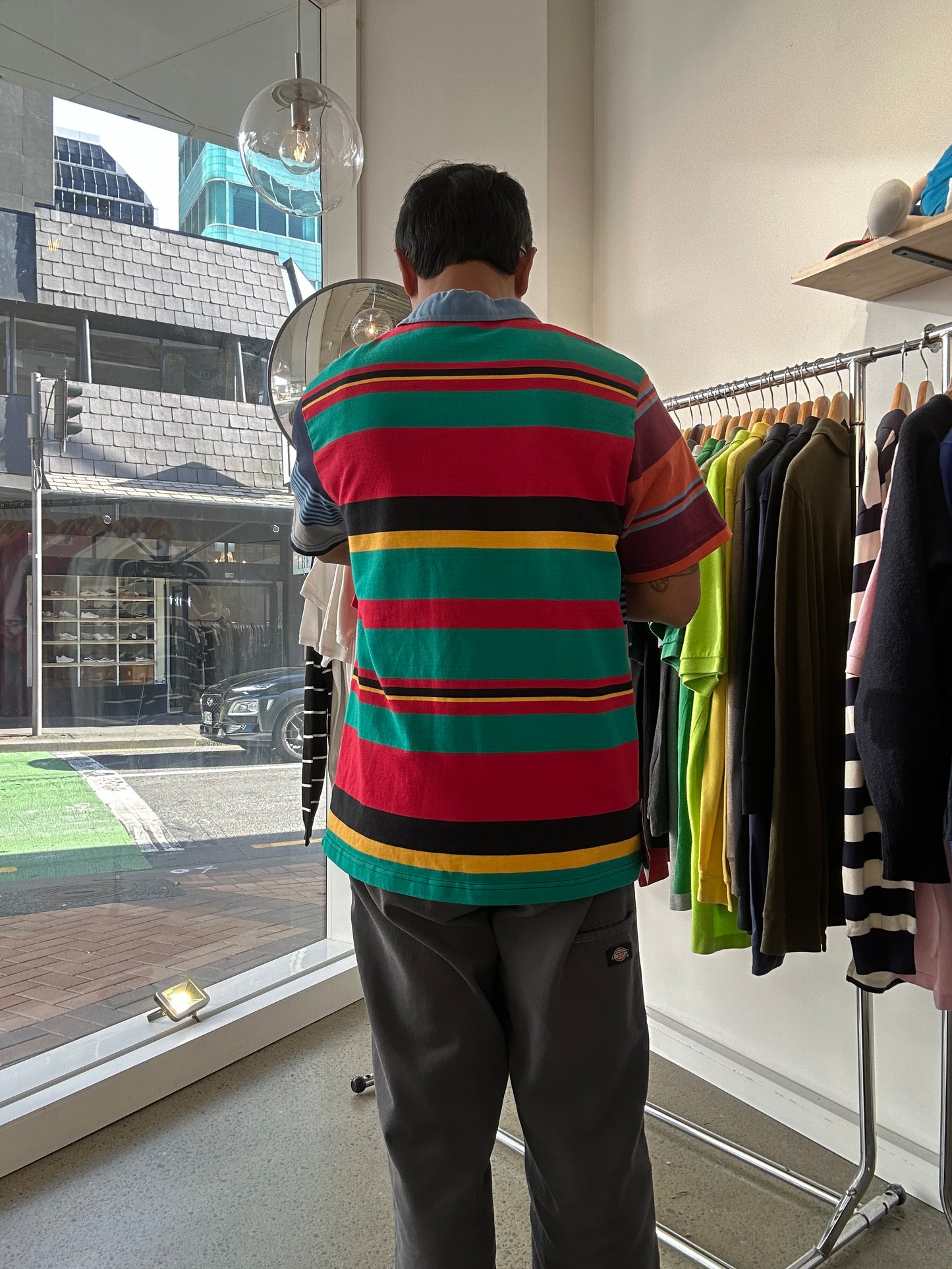 Canterbury of New Zealand short-sleeve rugby jersey features a distinctive multicolored striped design with a large logo