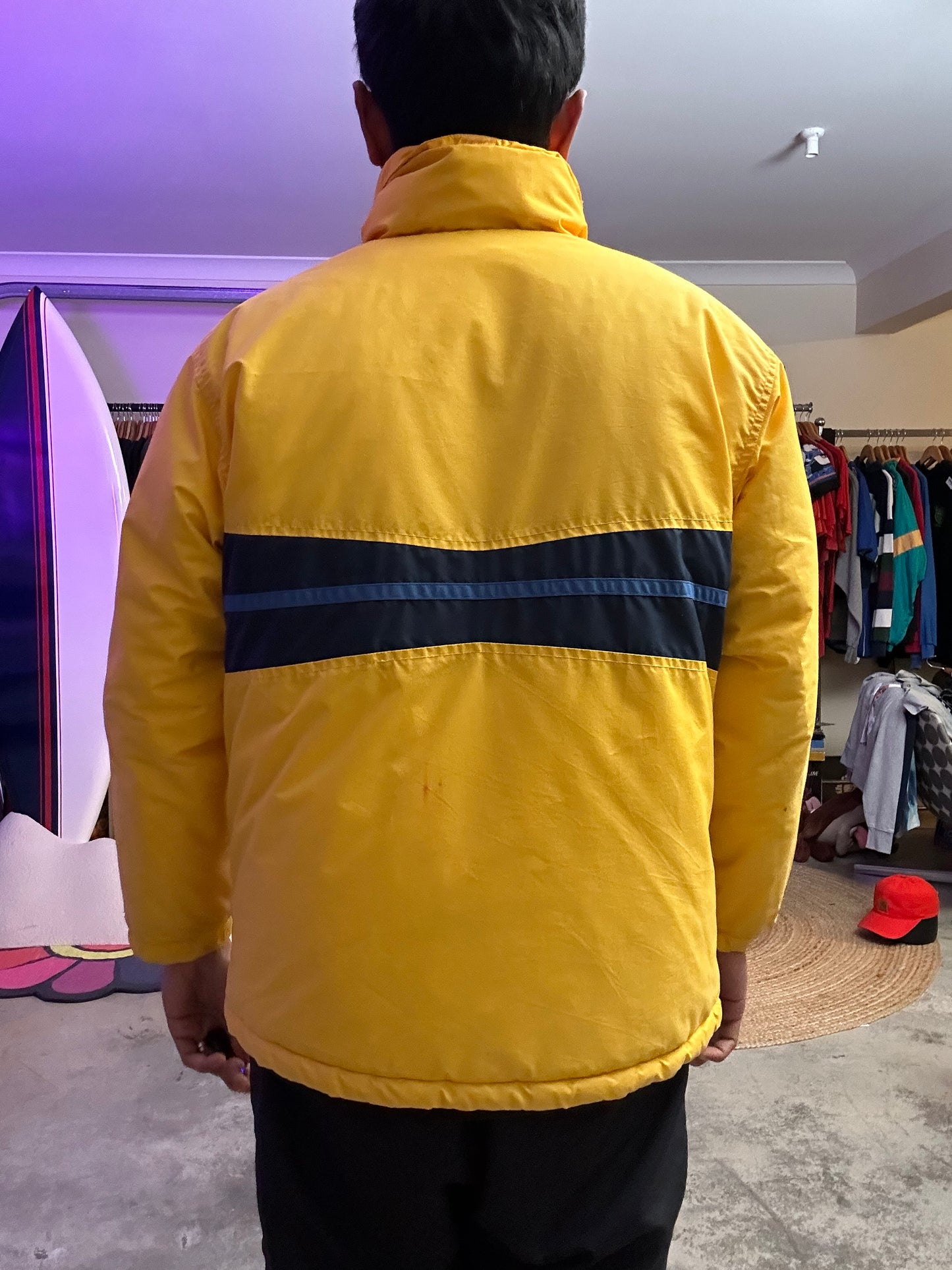Medium vintage yellow Columbia Sportswear jacket with a blue stripe design across the chest. Has Stains