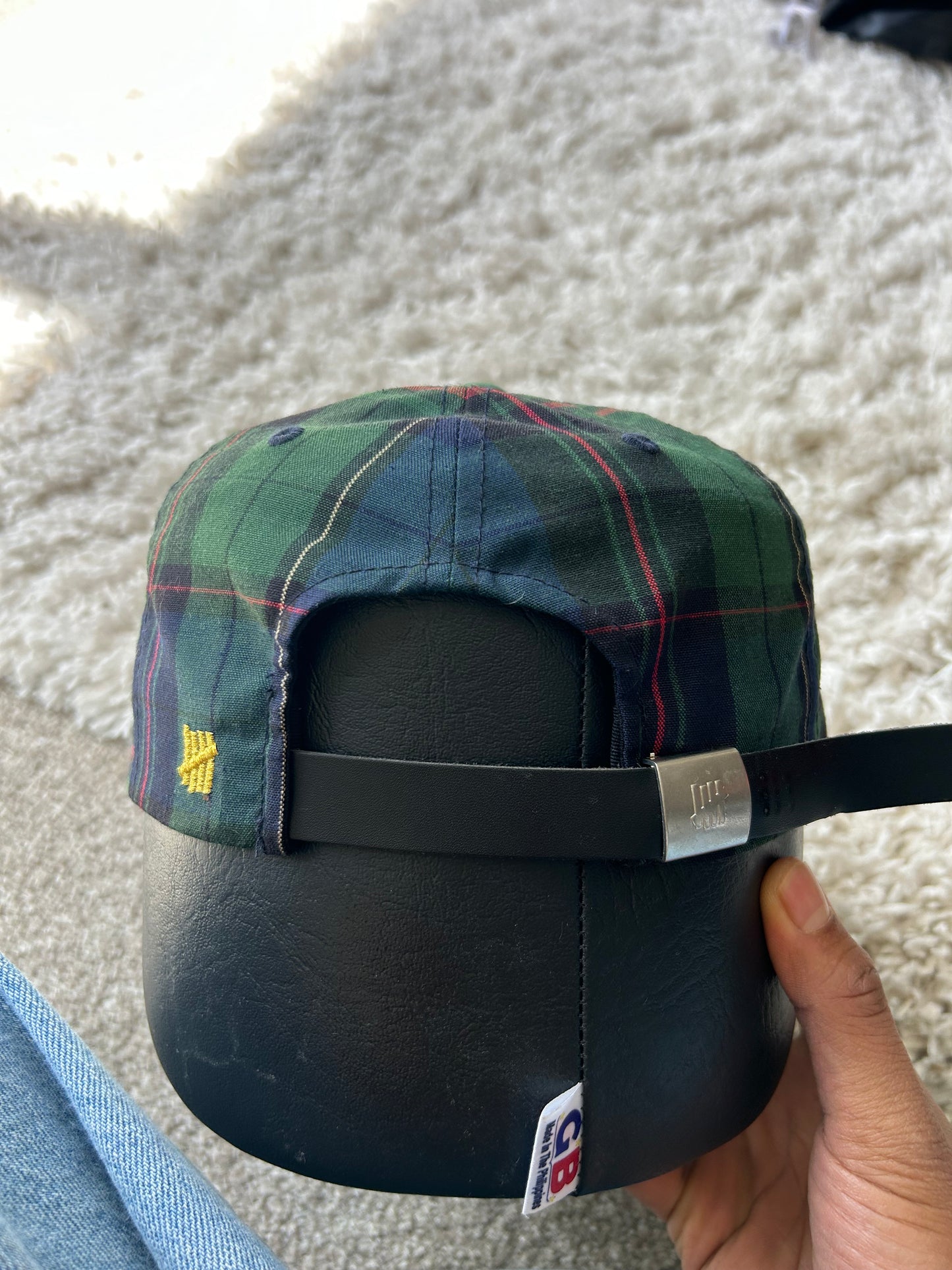 green and plaid Undefeated cap with a yellow embroidered "U" logo. Adjustable