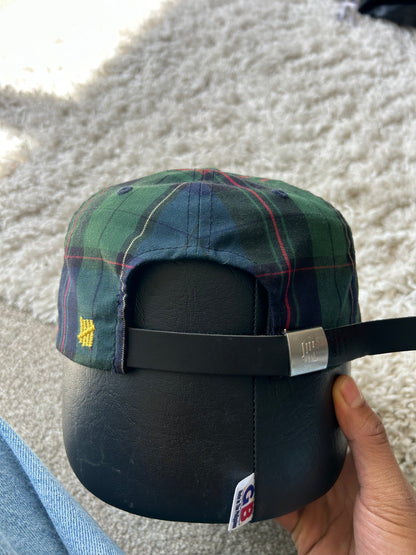 green and plaid Undefeated cap with a yellow embroidered "U" logo. Adjustable