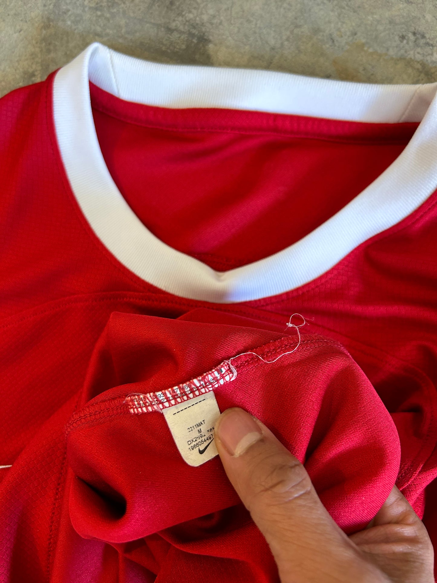 Nike Liverpool FC 2023/24 Home Jersey, featuring a classic red design with prominent white collar and sleeve cuffs. Medium