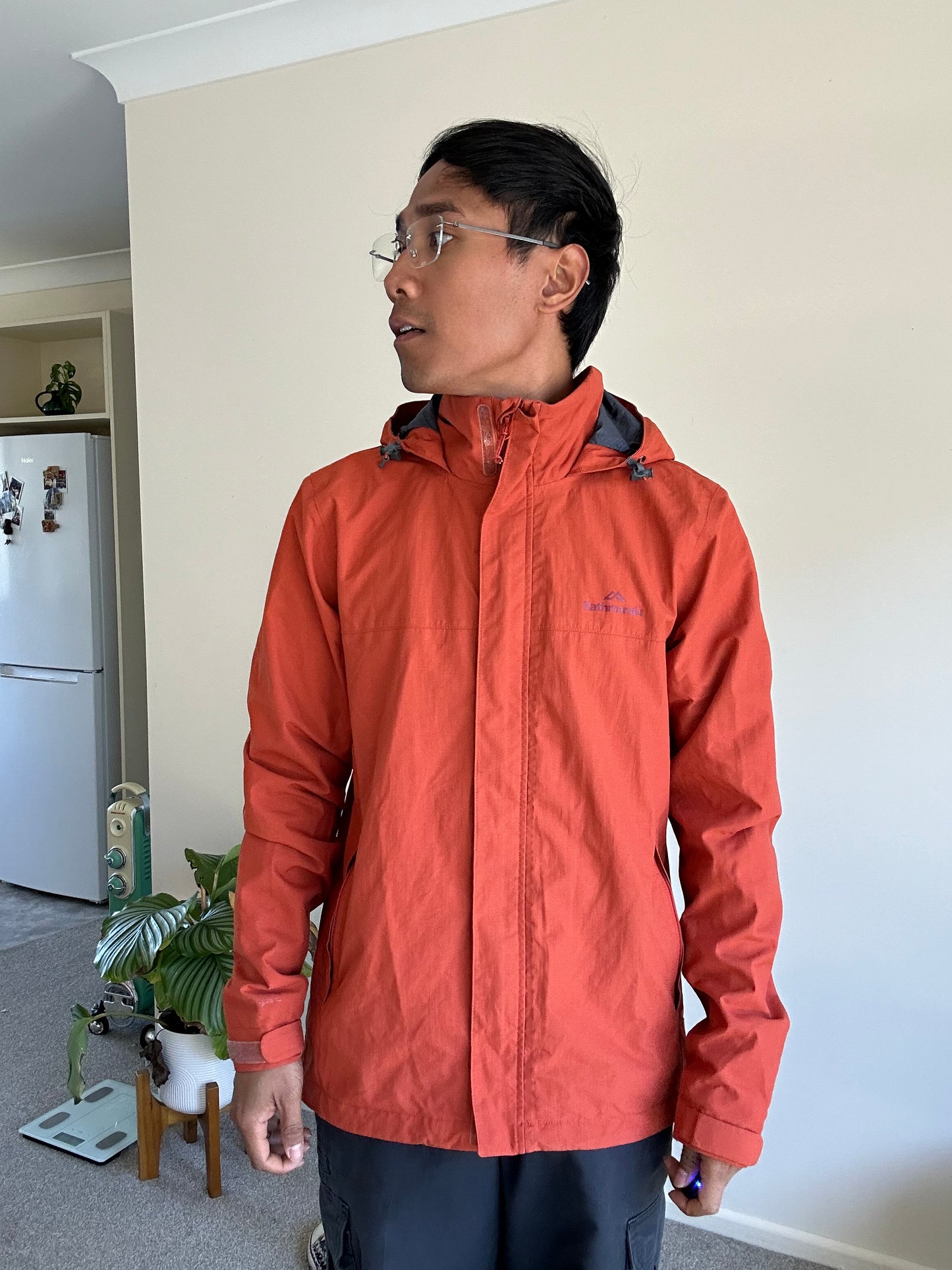 Kathmandu men's Andulo 2-layer rain jacket in a dark orange color Medium