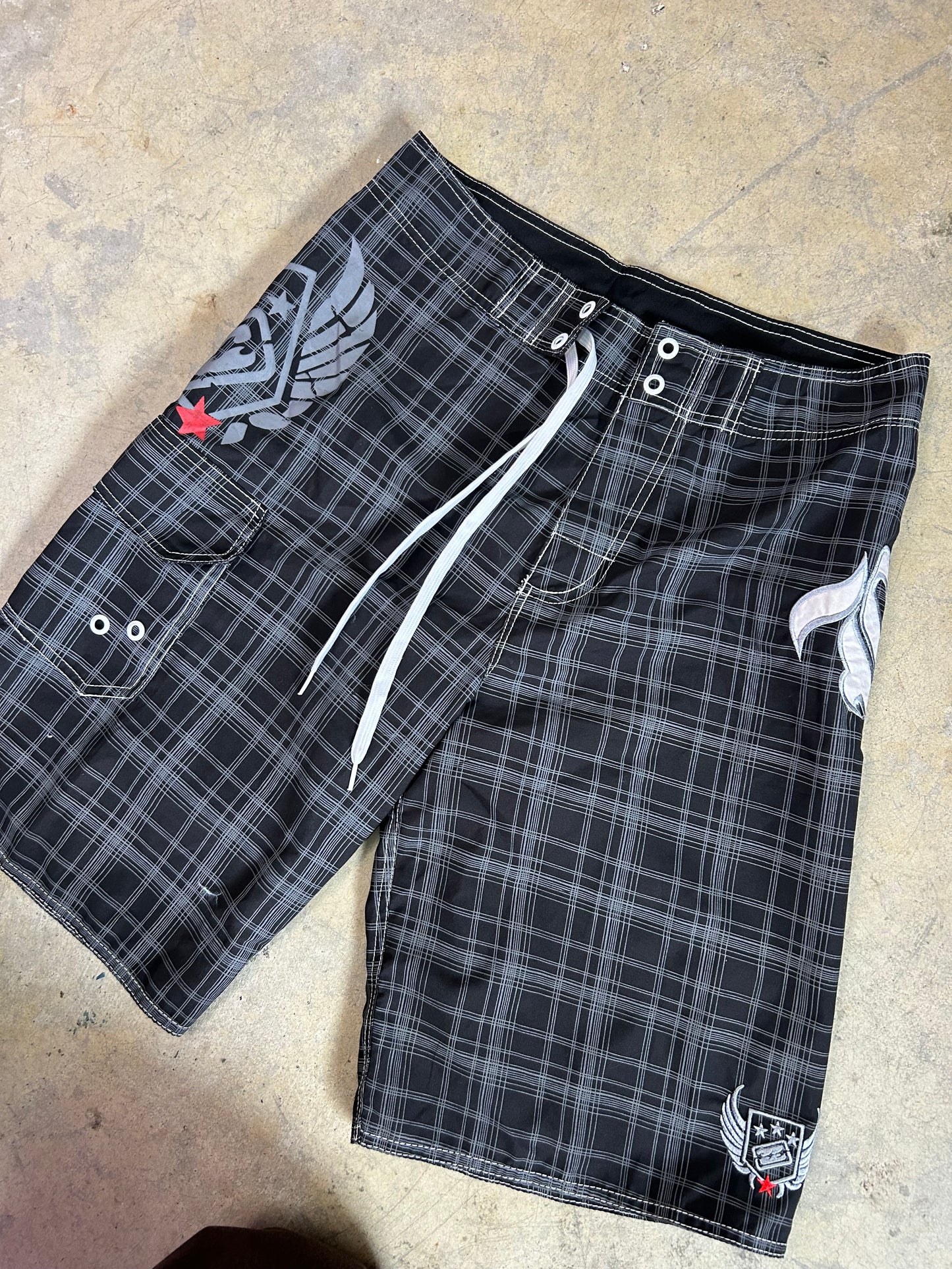 2000s Billabong black and grey plaid board shorts featuring a large embroidered logo on the back 32