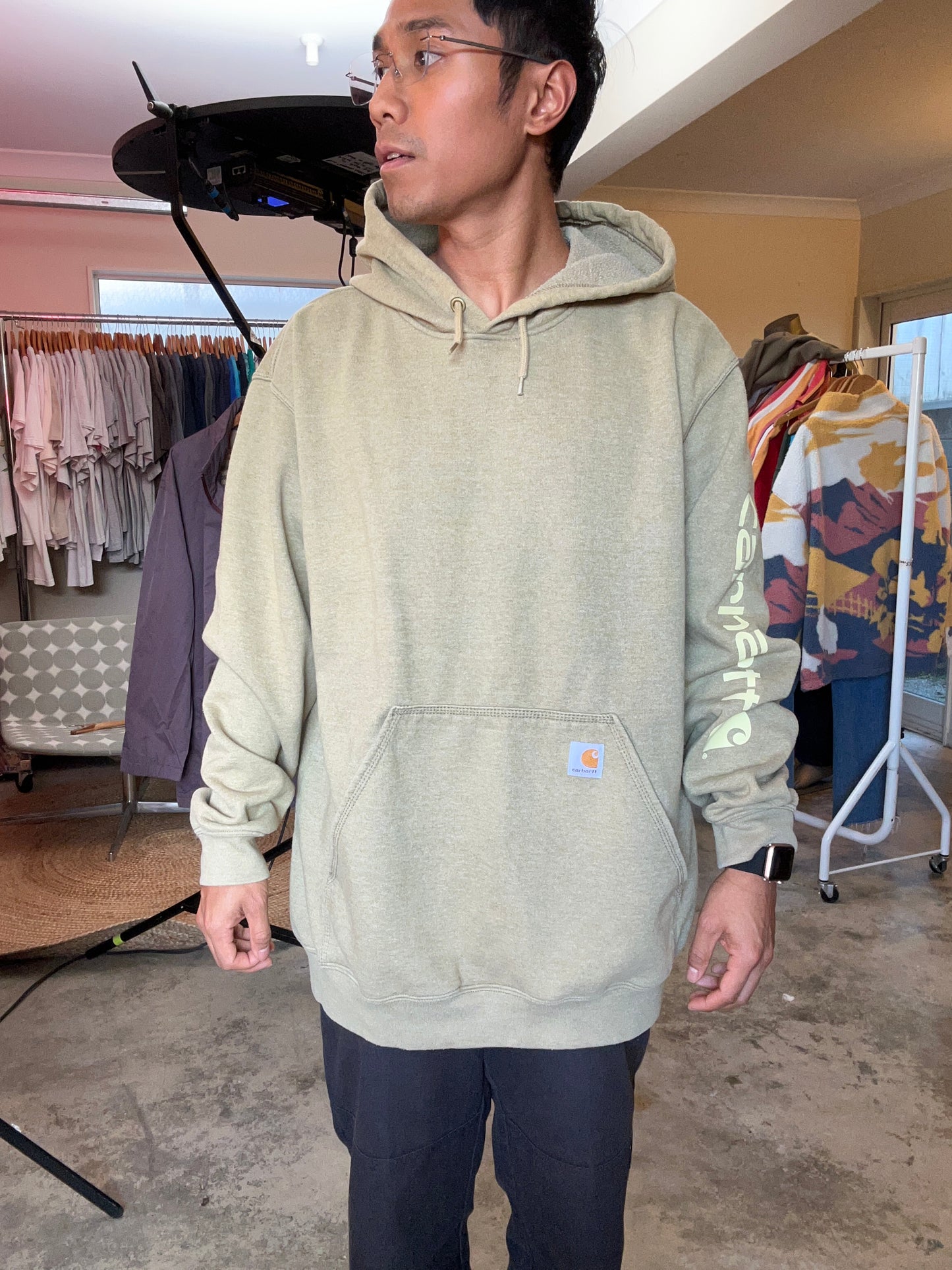 olive Carhartt K288 hooded sweatshirt features a "Carhartt" graphic printed down the left sleeve XL