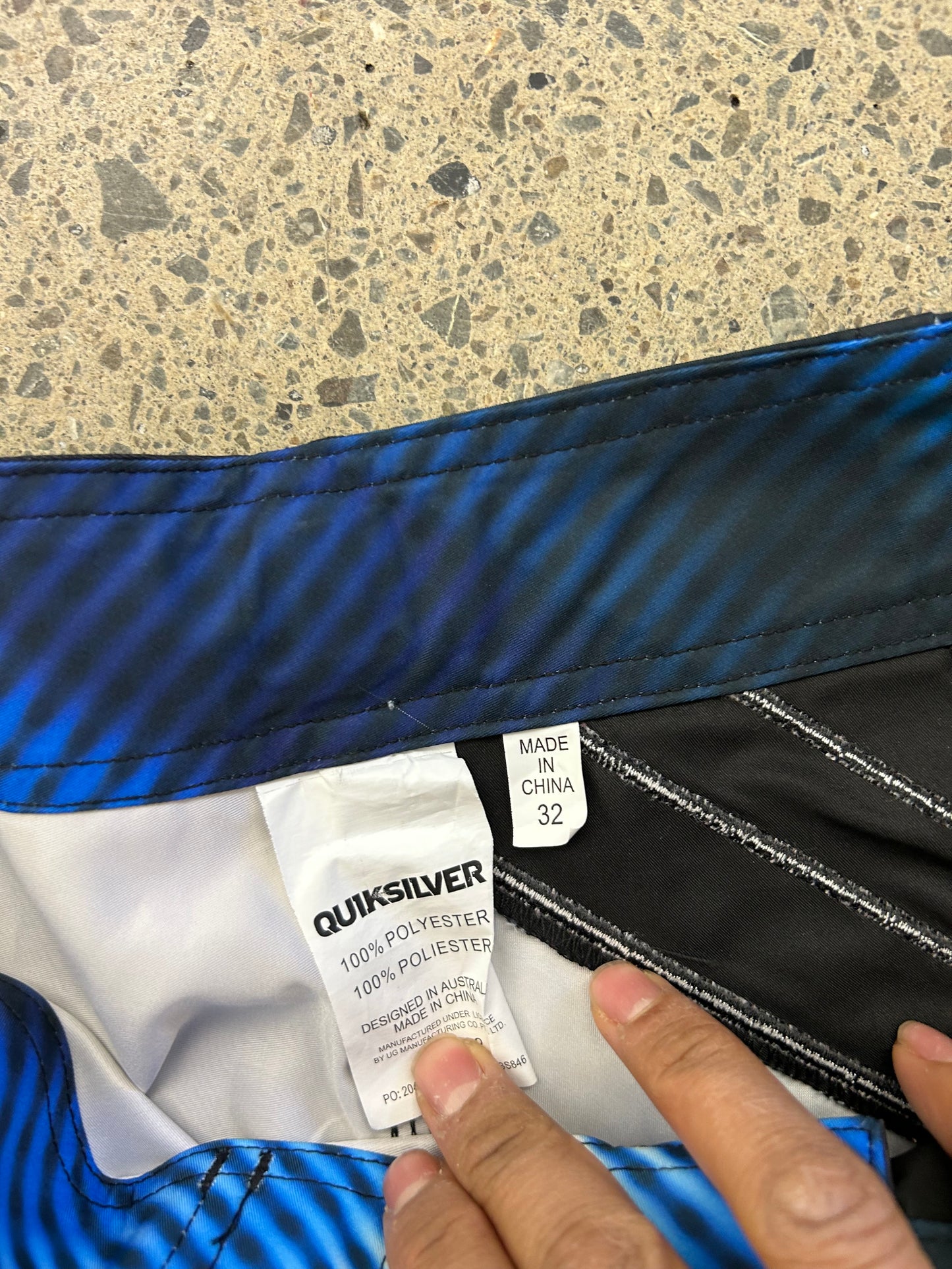 Quiksilver board shorts featuring a black and blue design with diagonal striped detailing size 32