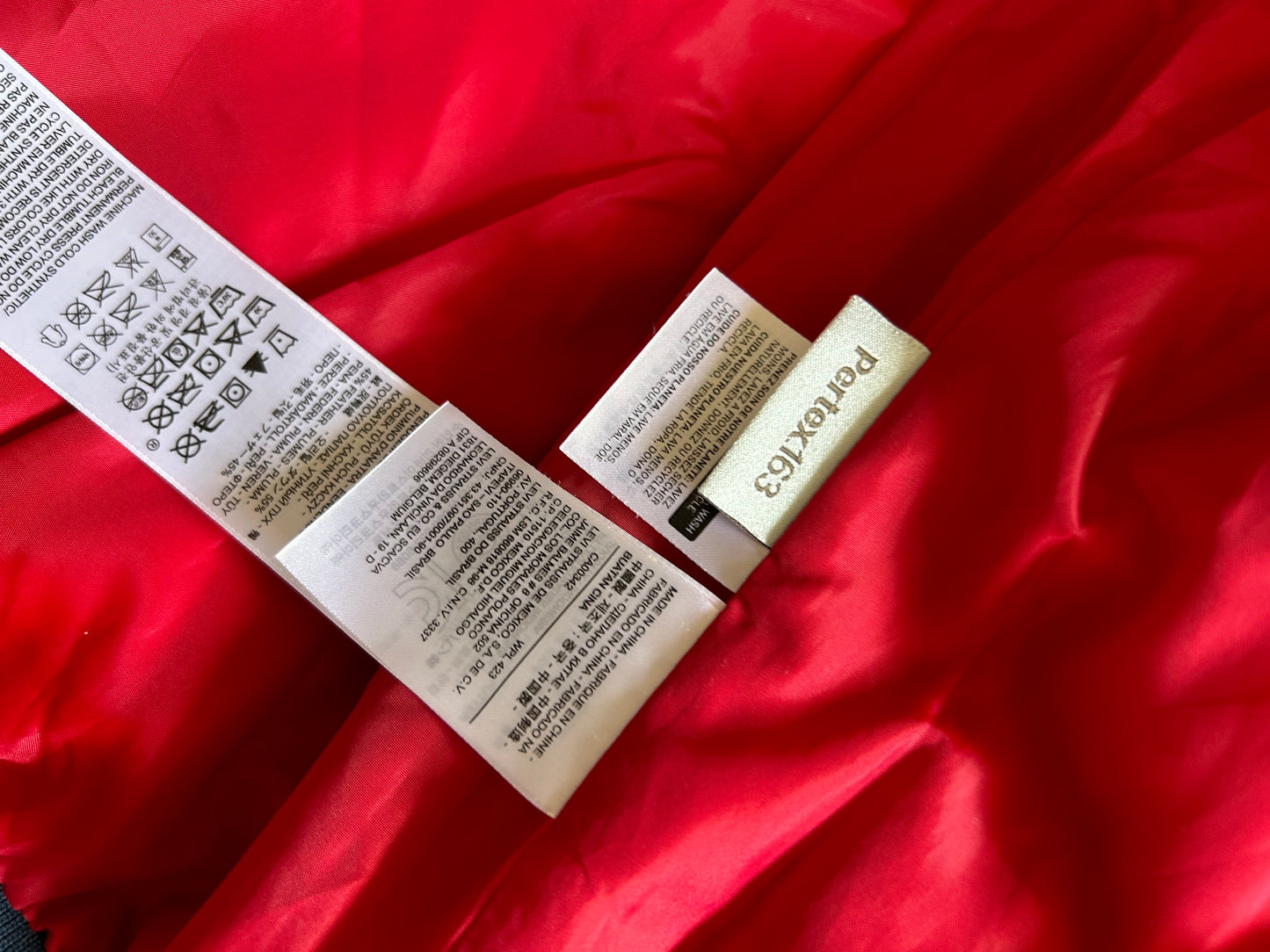 Pertex blue puffer jacket with a red inner lining and red zippers, produced by Levi's Small