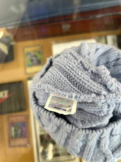 light blue or grey cable-knit wool beanie featuring a Canada Goose arctic disc logo patch on the front