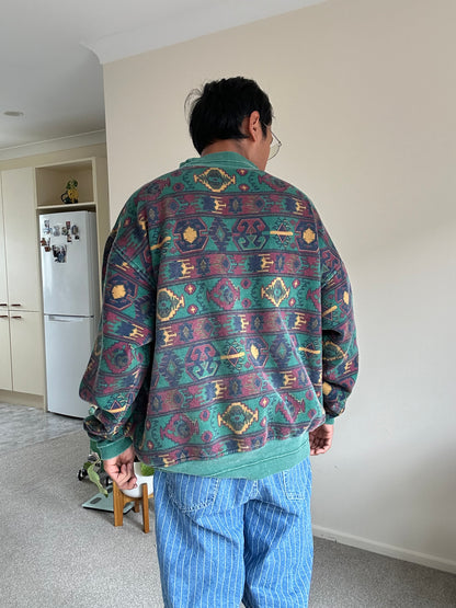 a dark green base with a multicolored Aztec and geometric pattern, characteristic of 1980s and 90s knitwear designs. XL