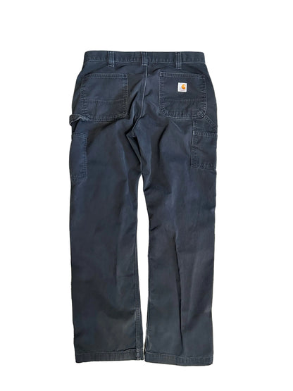 vintage Carhartt Carpenter pants, characterized by a faded black finish and utility features like a hammer loop size 36