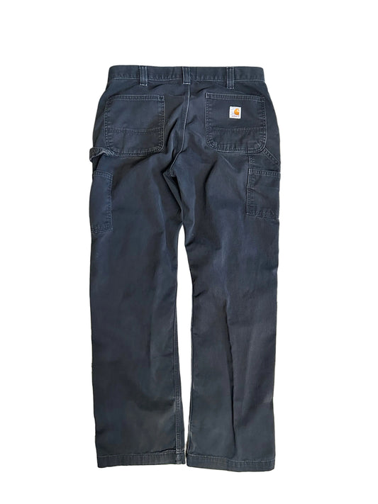 vintage Carhartt Carpenter pants, characterized by a faded black finish and utility features like a hammer loop size 36