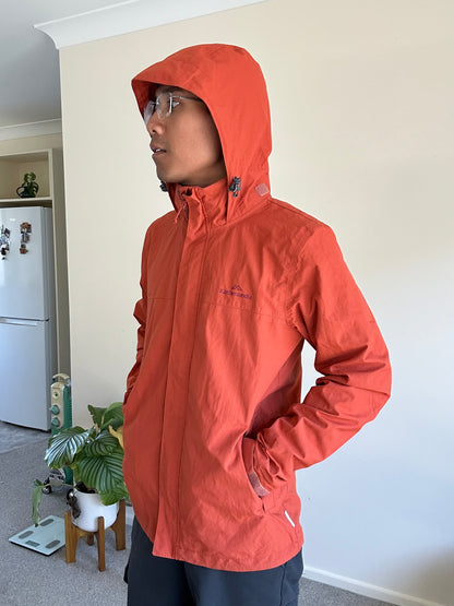 Kathmandu men's Andulo 2-layer rain jacket in a dark orange color Medium