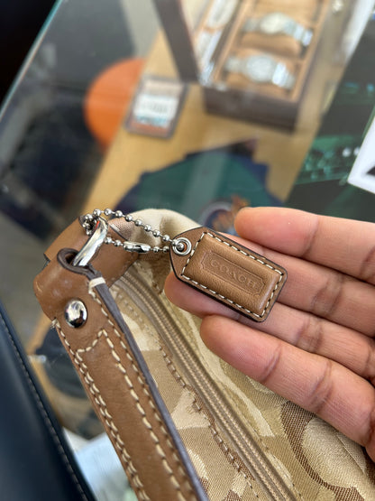 vintage Coach signature jacquard mini shoulder bag featuring the iconic brown "C" monogram pattern and a handy front pocket with a snap closure.