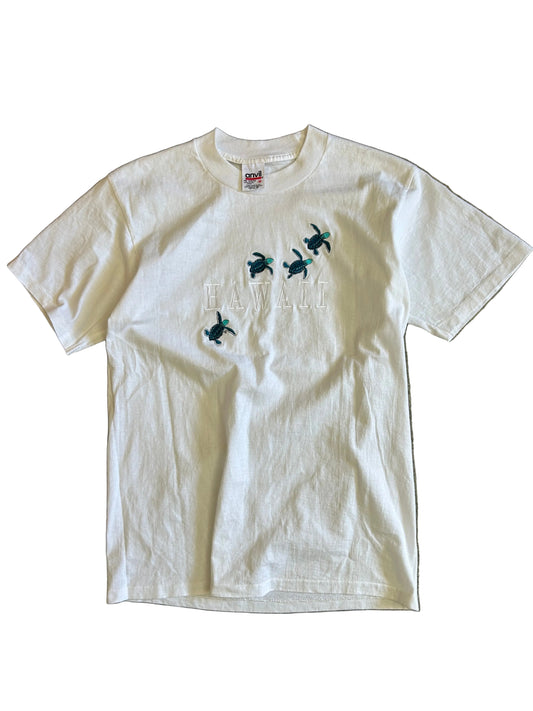 Vintage white t-shirt is an Anvil brand garment featuring embroidered turtle graphics and the word "HAWAII" on the front Medium