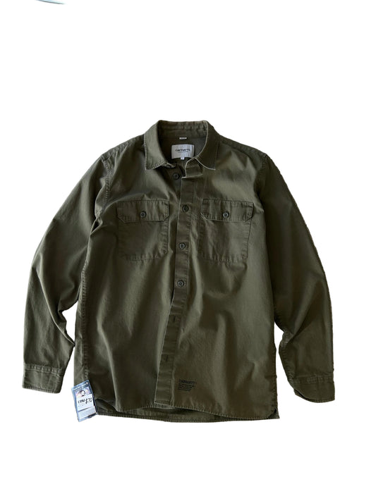 WIP olive green Carhartt long-sleeve work shirt with dual chest pockets and a small tag detail at the lower hem Large