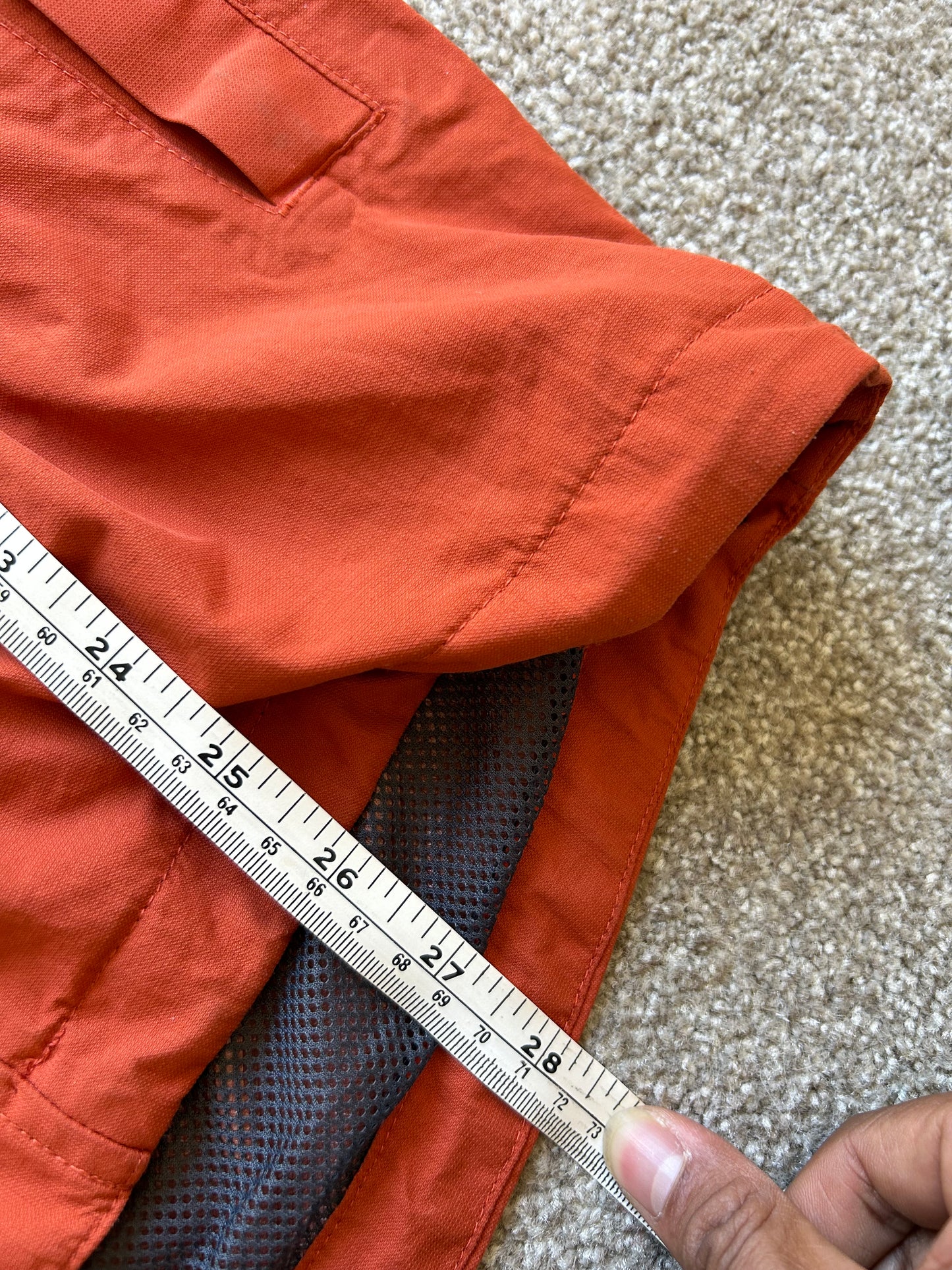 Kathmandu men's Andulo 2-layer rain jacket in a dark orange color Medium