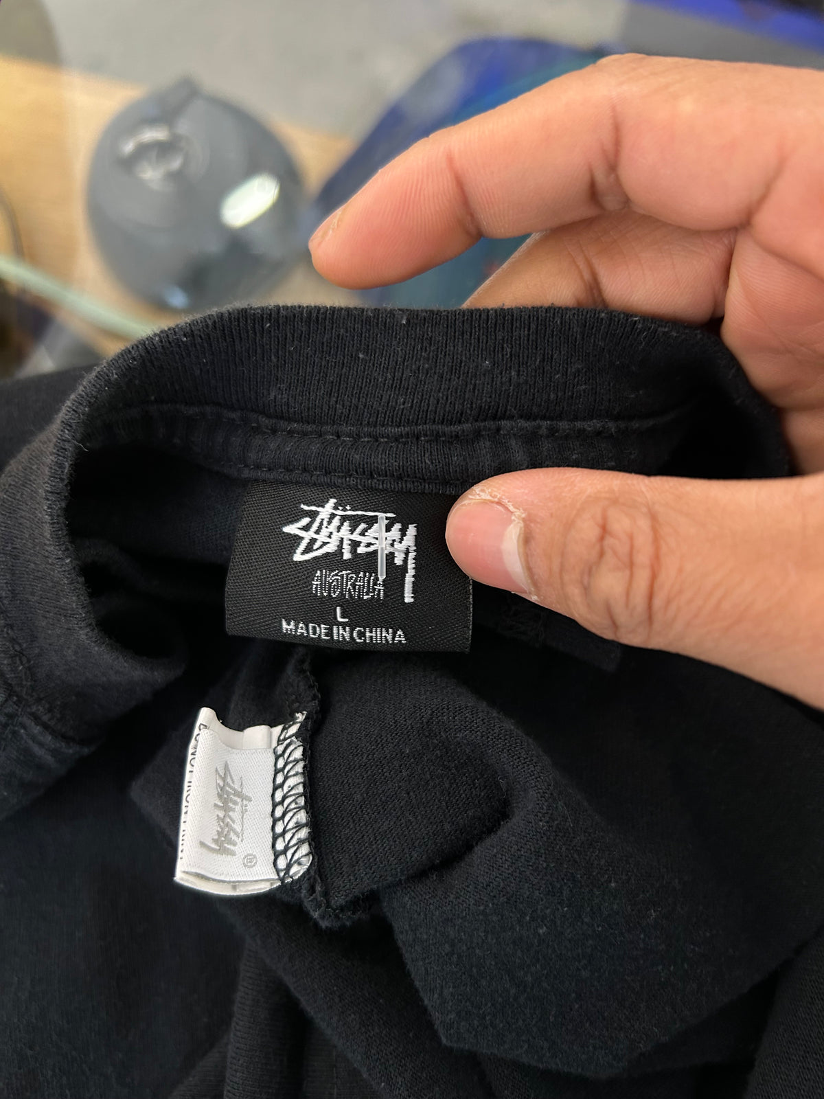 Stüssy Fuzzy Dice Tee in black, featuring a prominent fuzzy dice graphic on the back. Large