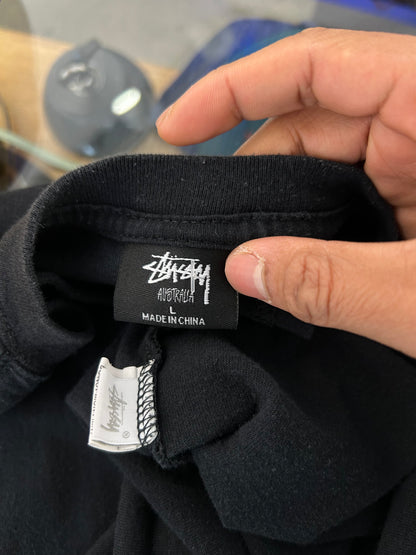 Stüssy Fuzzy Dice Tee in black, featuring a prominent fuzzy dice graphic on the back. Large
