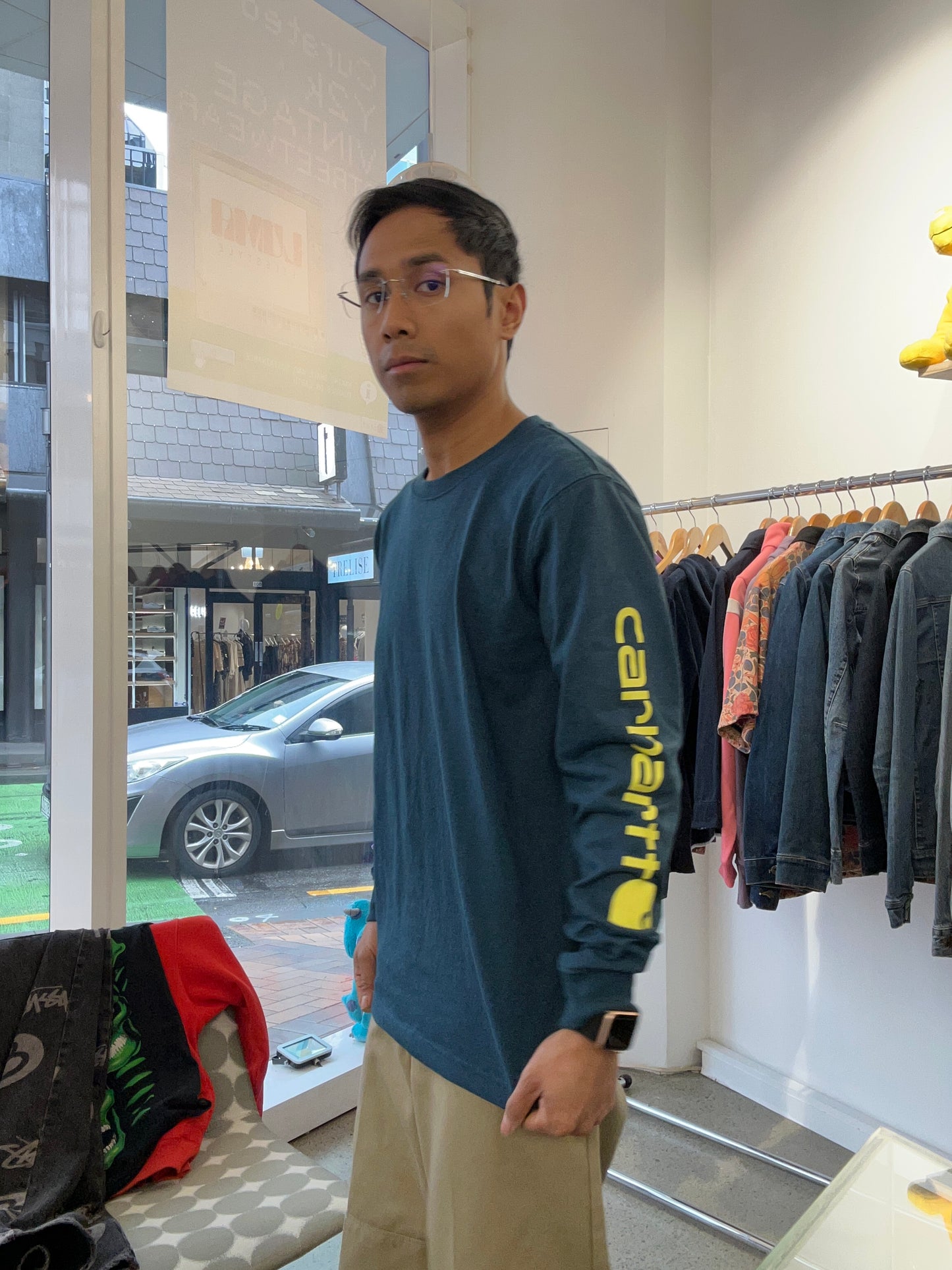 Carhartt Relaxed Fit Heavyweight Long-Sleeve Logo Sleeve Graphic T-Shirt in night blue heather with bold yellow lettering down the sleeve. Small