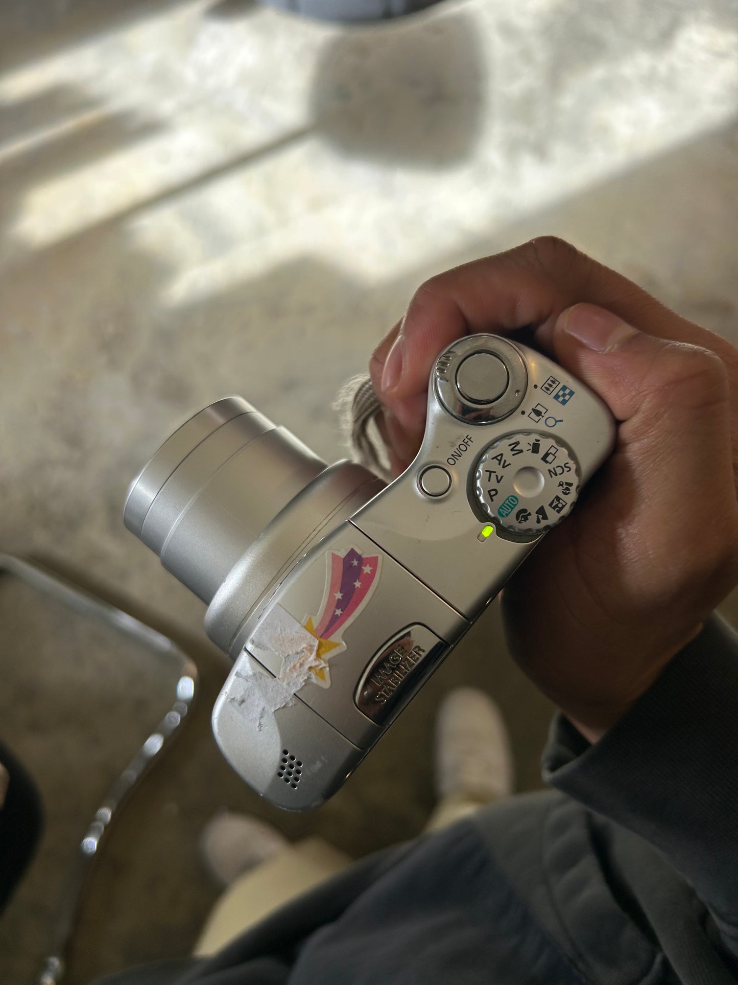 silver Canon PowerShot SX100 IS digital camera with a 10x optical zoom lens