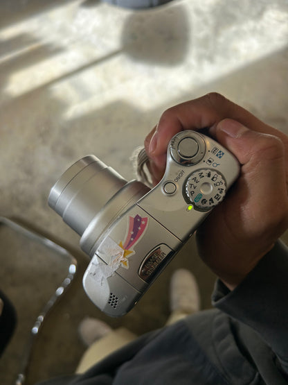 silver Canon PowerShot SX100 IS digital camera with a 10x optical zoom lens
