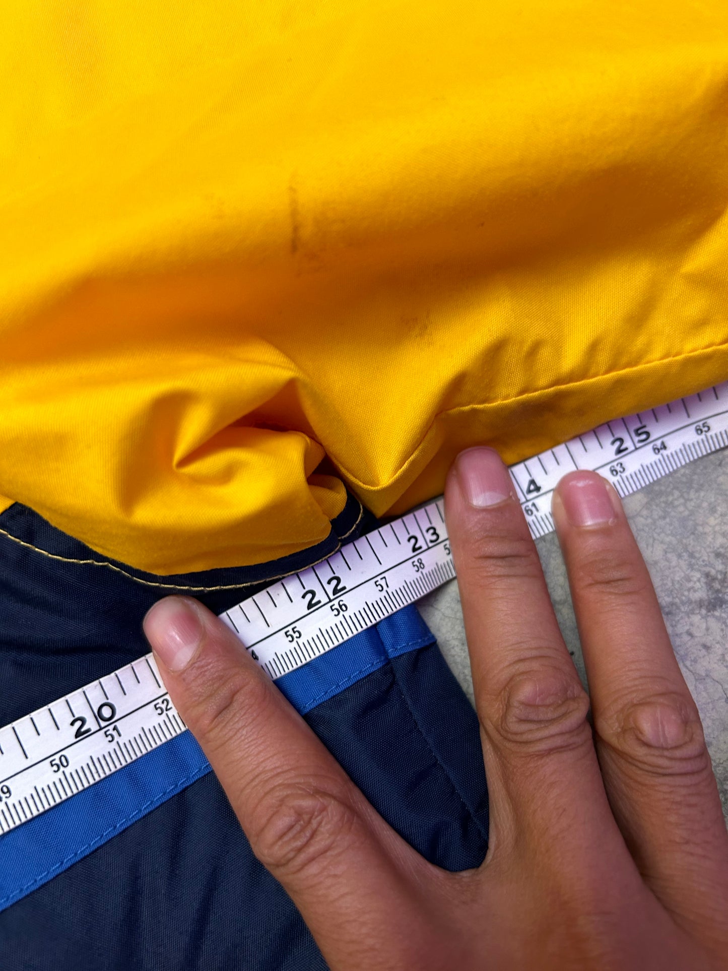 Medium vintage yellow Columbia Sportswear jacket with a blue stripe design across the chest. Has Stains