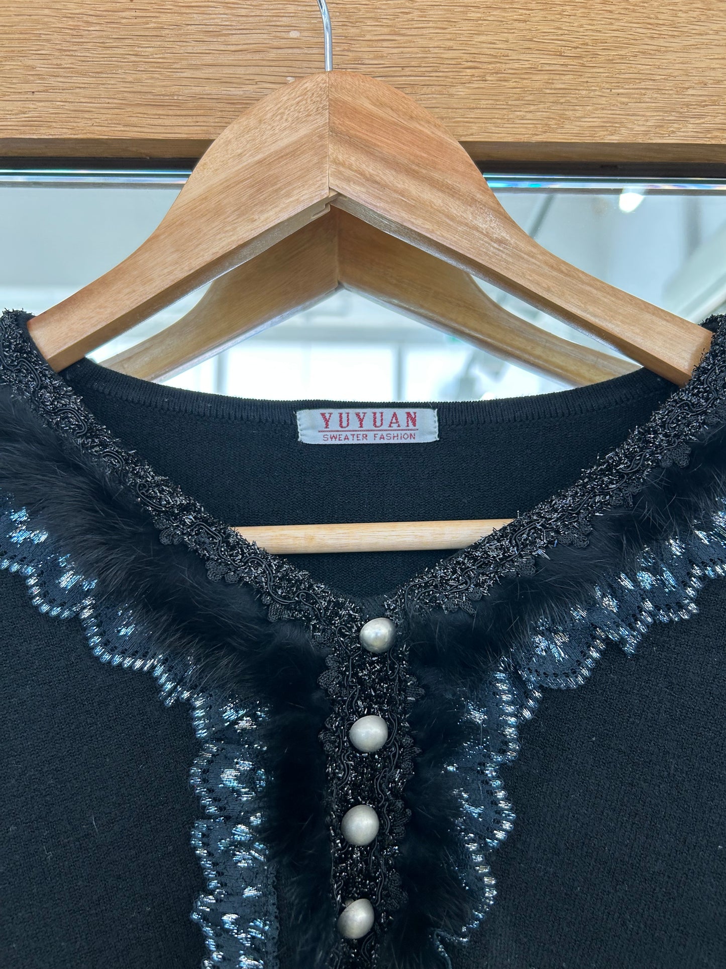 Yuyuan black long-sleeve sweater features a V-neckline adorned with delicate lace trim and pearl-like button details