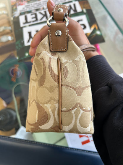 vintage Coach signature jacquard mini shoulder bag featuring the iconic brown "C" monogram pattern and a handy front pocket with a snap closure.