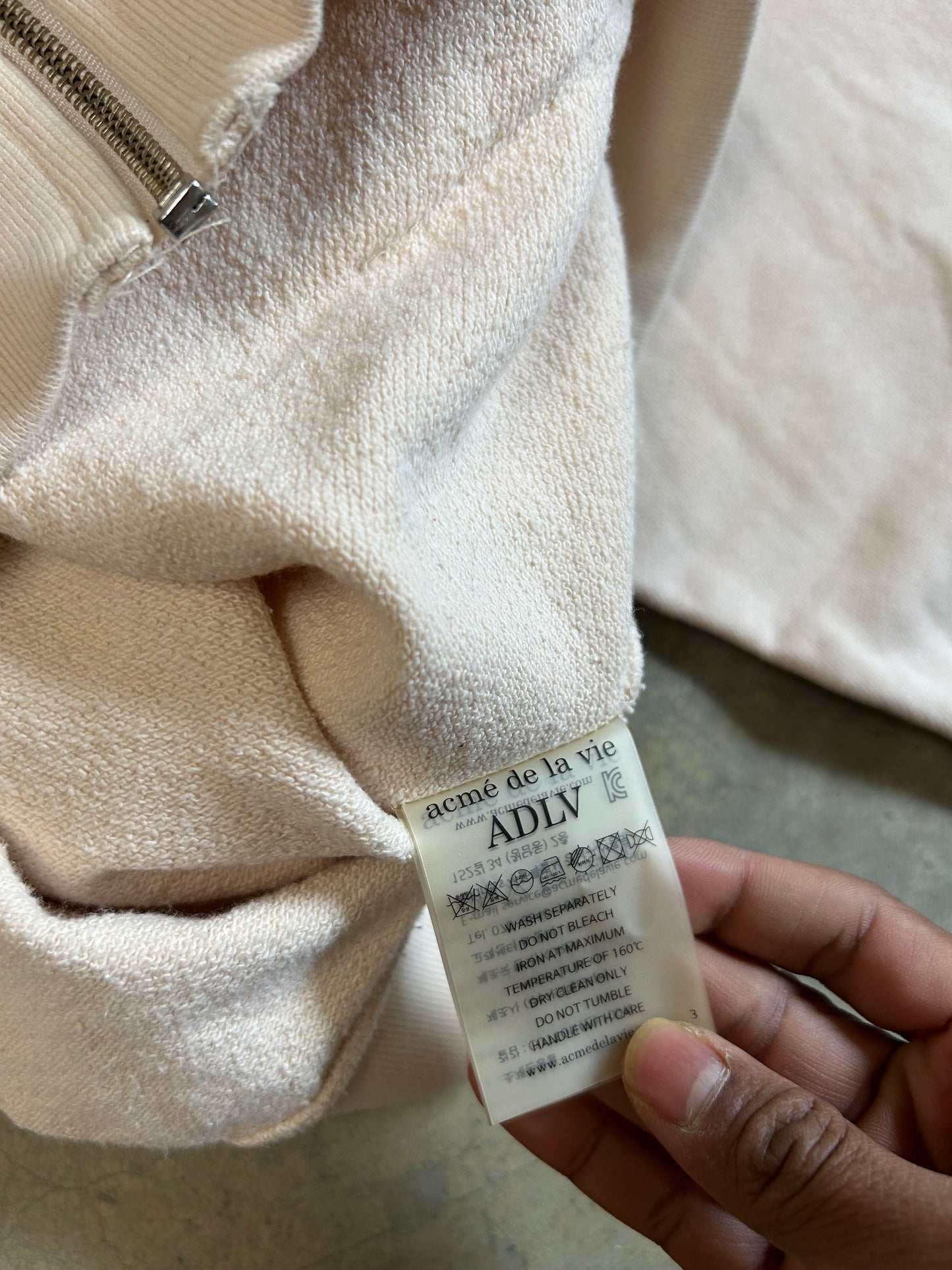 cream-colored zip-up hoodie  "Acmé de la Vie" (ADLV)