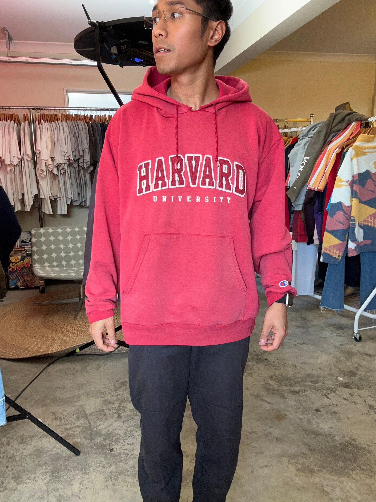 Vintage Fade red Champion hoodie features a prominent arched "HARVARD" spellout graphic and a comfortable kangaroo pocket Large
