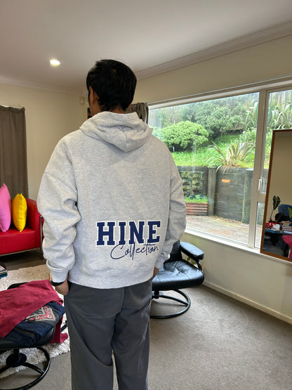 Hine Collection gray hoodie features a prominent navy blue "HC" embroidered logo on the chest