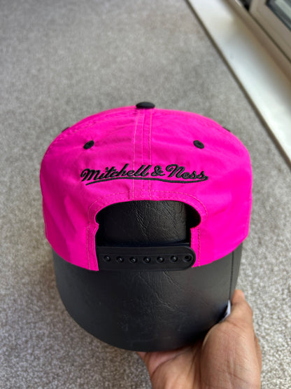 Pink and Black Mitchell & Ness San Antonio Spurs Hardwood Classics Snapback hat.