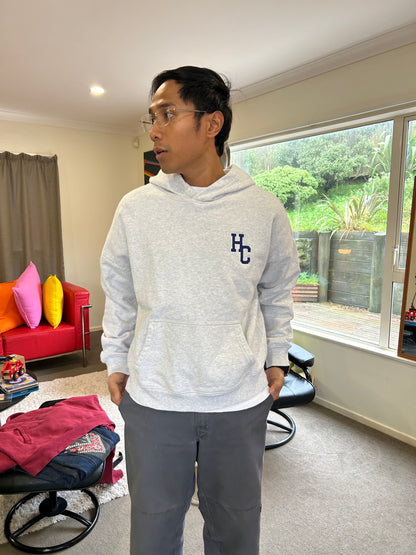 Hine Collection gray hoodie features a prominent navy blue "HC" embroidered logo on the chest