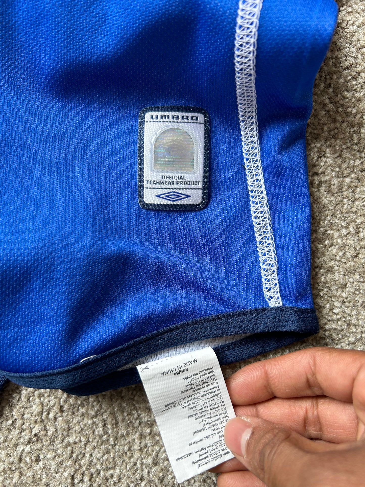 vibrant blue Umbro performance jersey featuring a V-neck design and white piping details XL