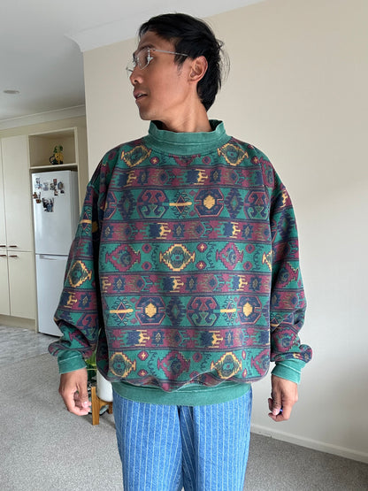 a dark green base with a multicolored Aztec and geometric pattern, characteristic of 1980s and 90s knitwear designs. XL