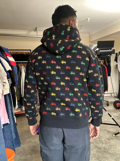 black, pullover-style hoodie featuring an all-over, multi-colored Stüssy logo print Small
