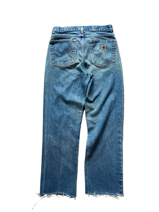 vintage Carhartt blue denim work jeans with a straight leg and distressed hem size 31