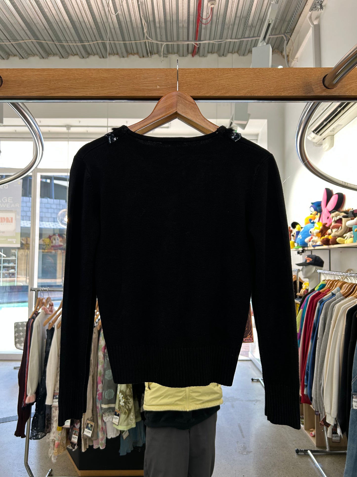 Yuyuan black long-sleeve sweater features a V-neckline adorned with delicate lace trim and pearl-like button details
