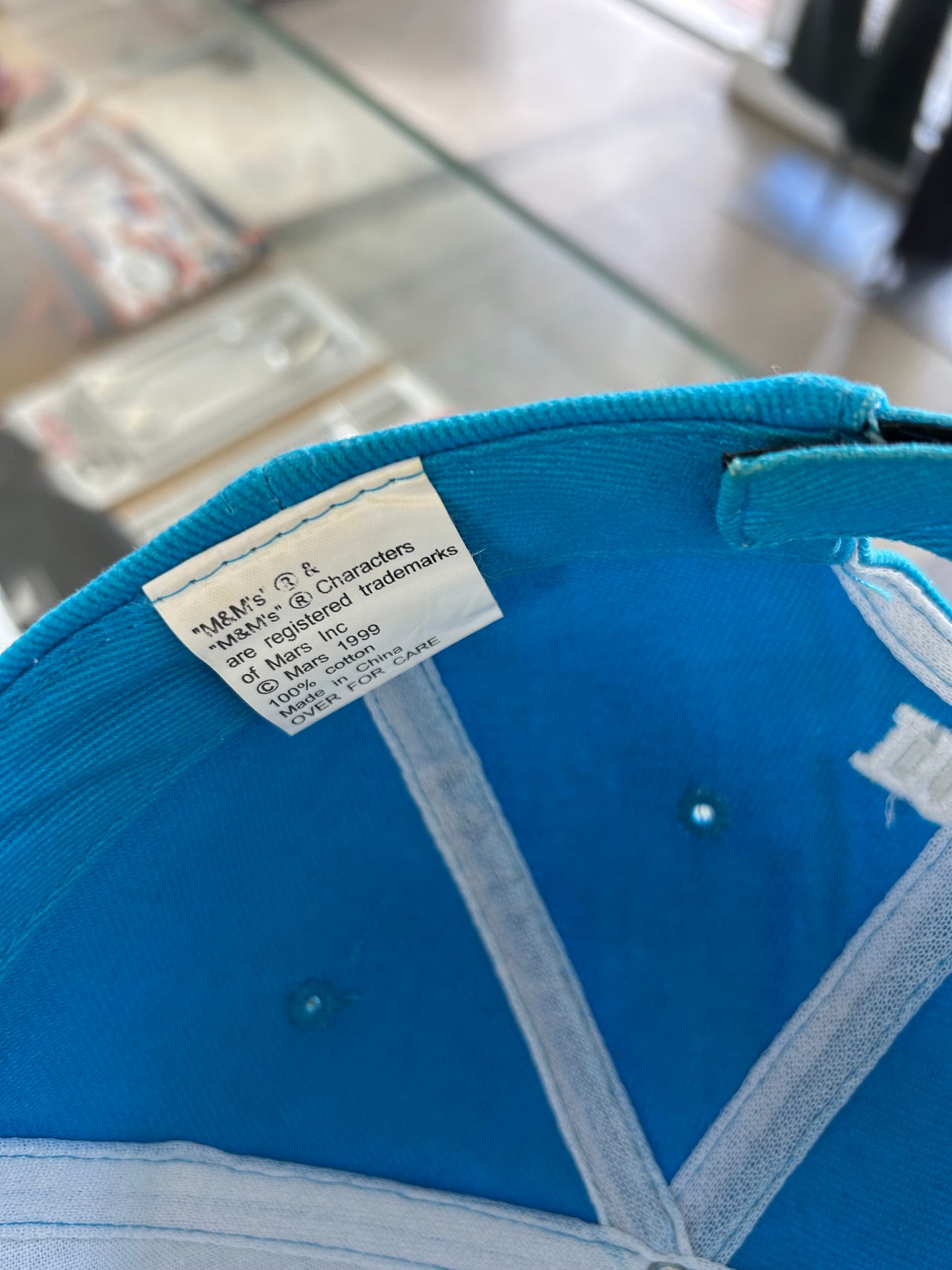 vintage 1999 M&M's Crispy "Orange" character advertising baseball cap in a vibrant turquoise blue.