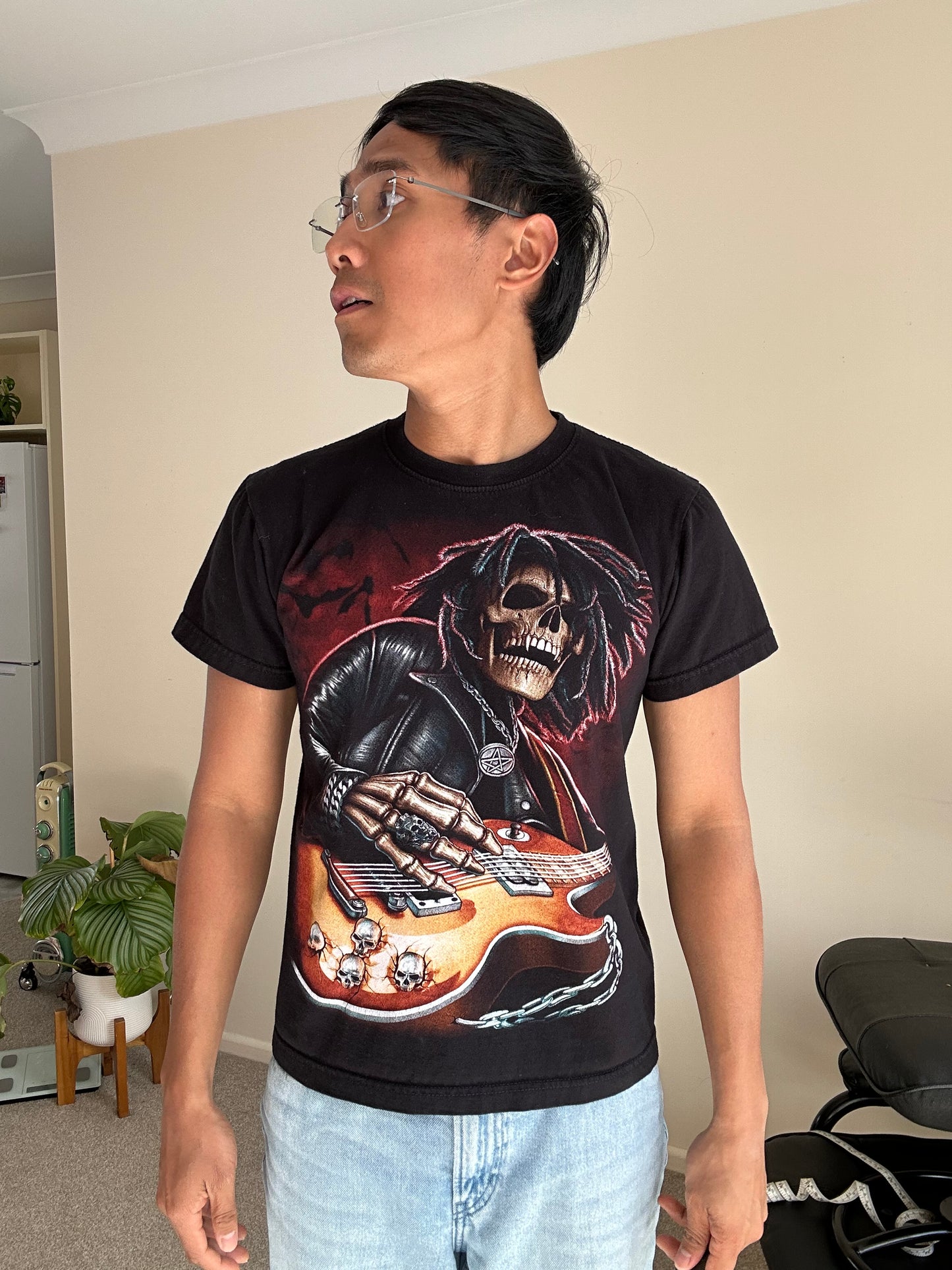 black graphic t-shirt featuring a skeleton playing an electric guitar Hot Rock Tee