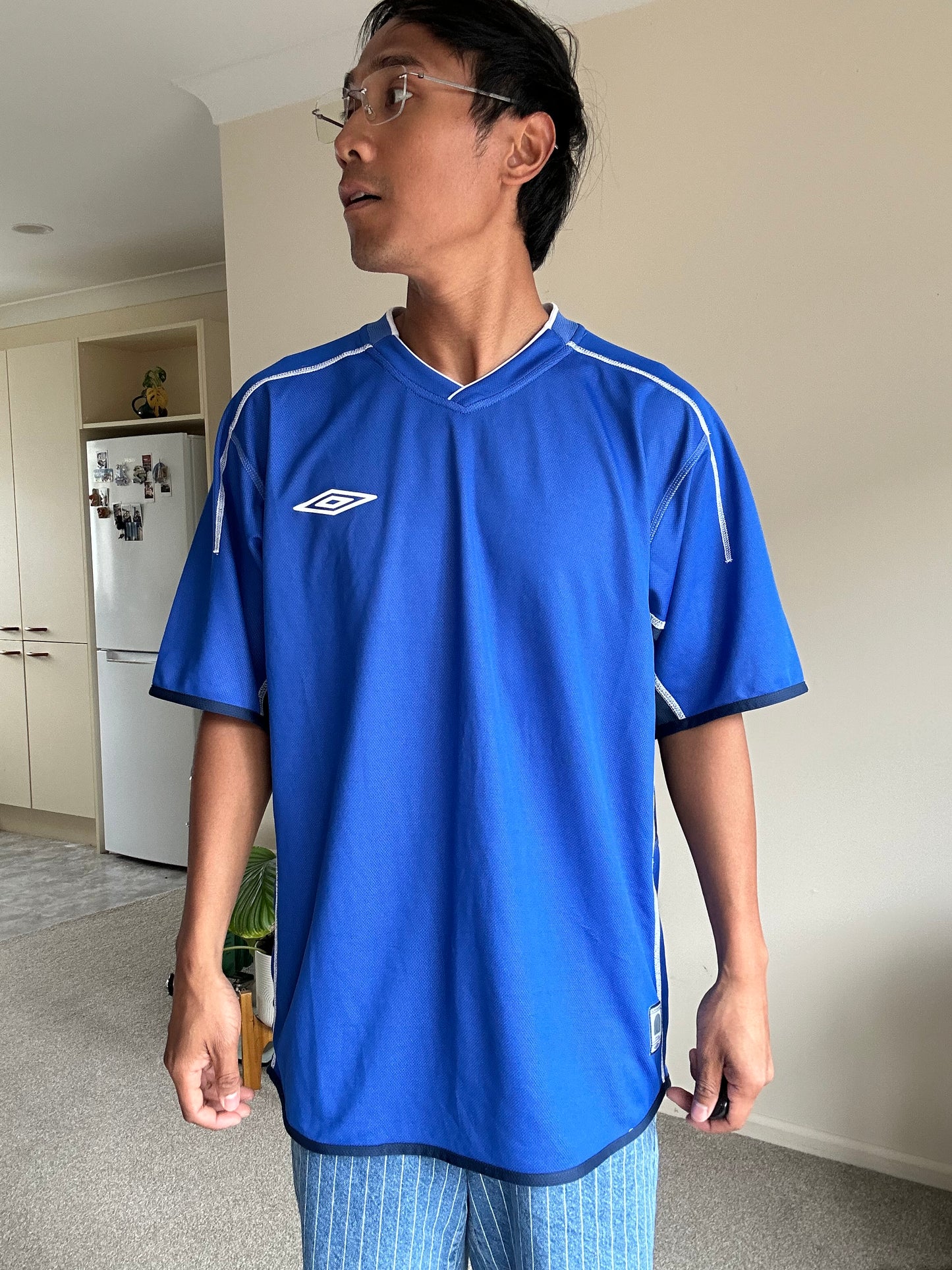 vibrant blue Umbro performance jersey featuring a V-neck design and white piping details XL