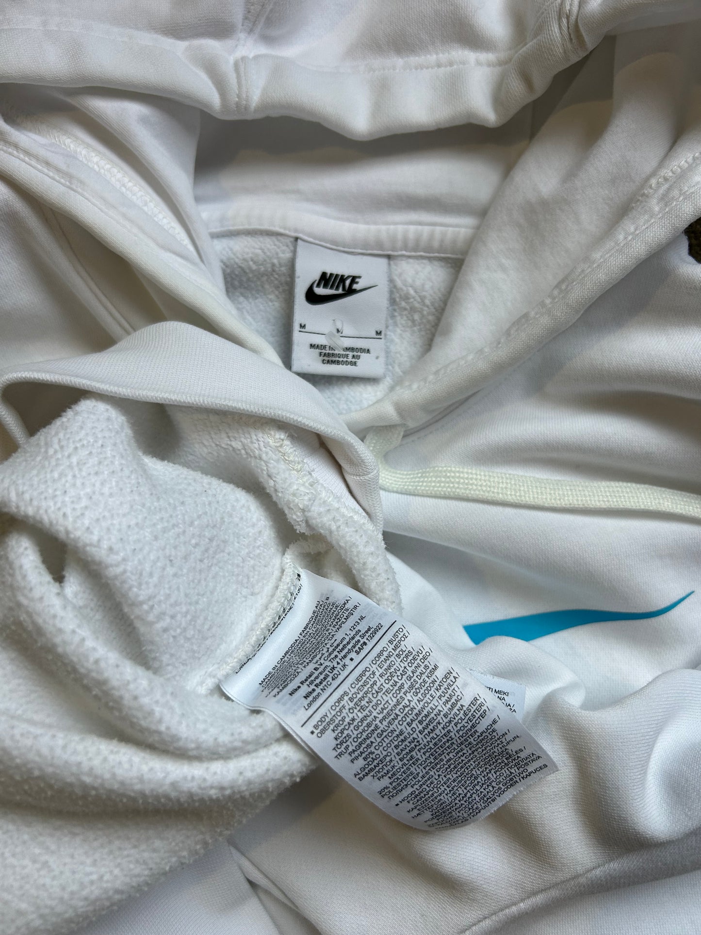 Nike Sportswear Repeat Fleece hoodie in summit white features distinctive Baltic blue branding on the chest and along the sleeves Medium