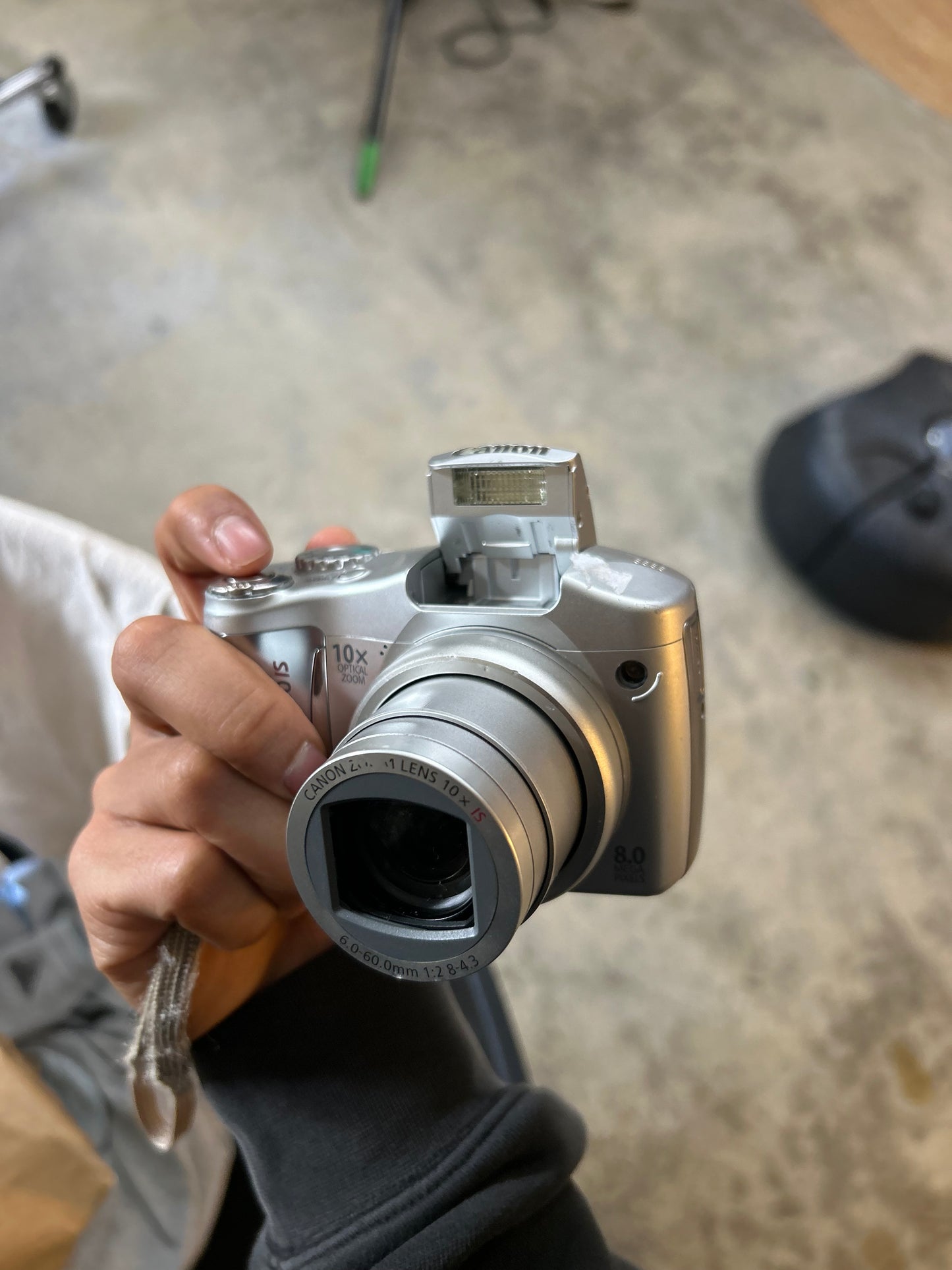 silver Canon PowerShot SX100 IS digital camera with a 10x optical zoom lens