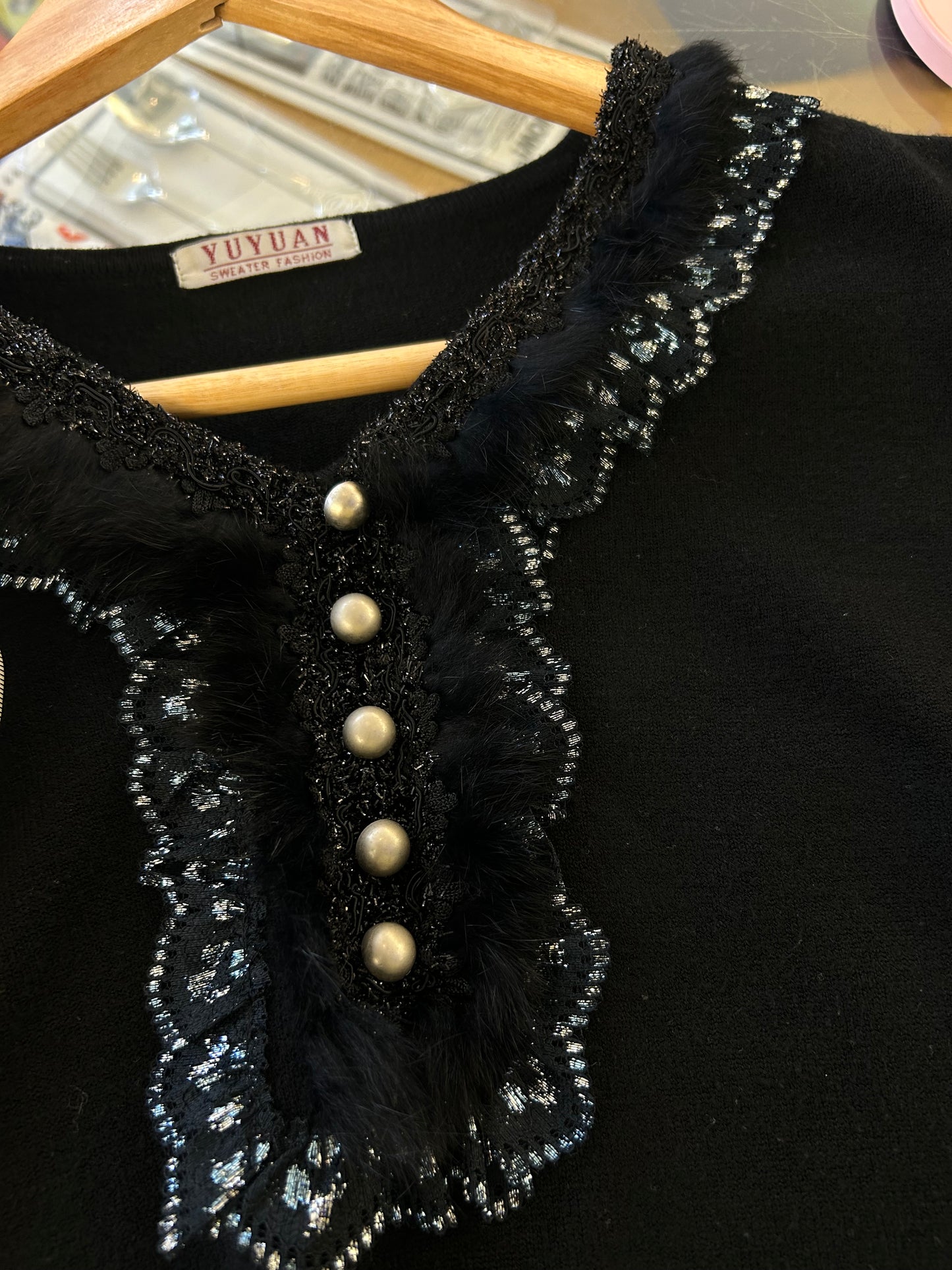 Yuyuan black long-sleeve sweater features a V-neckline adorned with delicate lace trim and pearl-like button details