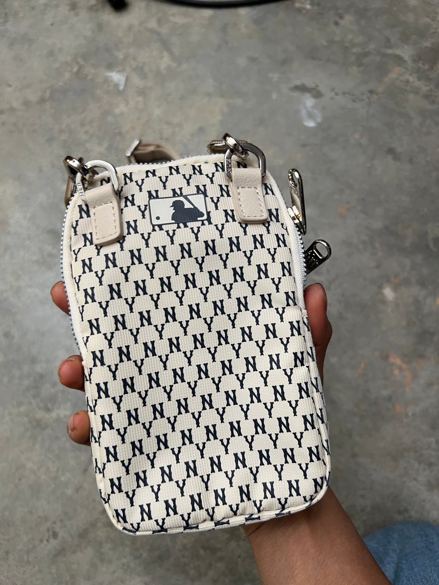 MLB New York Yankees mini bag features a repeating "NY" monogram pattern in ivory and blue