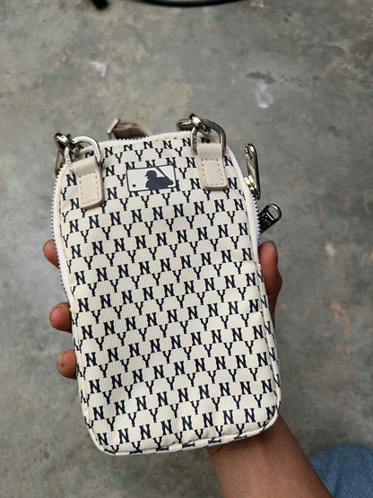 MLB New York Yankees mini bag features a repeating "NY" monogram pattern in ivory and blue