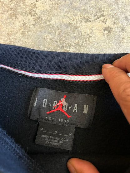 black Jordan Jumpman Men's Fleece Crew Sweatshirt, which features side pockets and a prominent white "JUMPMAN" graphic with the Nike swoosh Medium