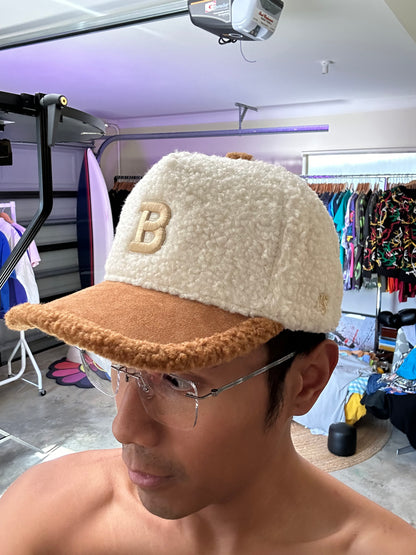 New Shepherds Sherpa Baseball Cap featuring a white fleece crown, a brown brim, and a gold embroidered 'B