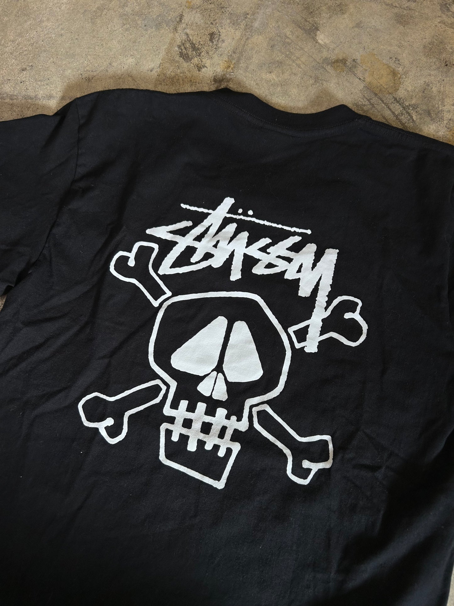 Stüssy Skull & Bones Pigment Dyed T-shirt in black, featuring a screen-printed graphic on the back XL