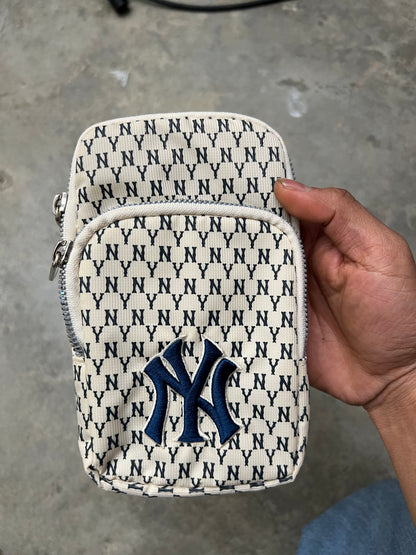 MLB New York Yankees mini bag features a repeating "NY" monogram pattern in ivory and blue