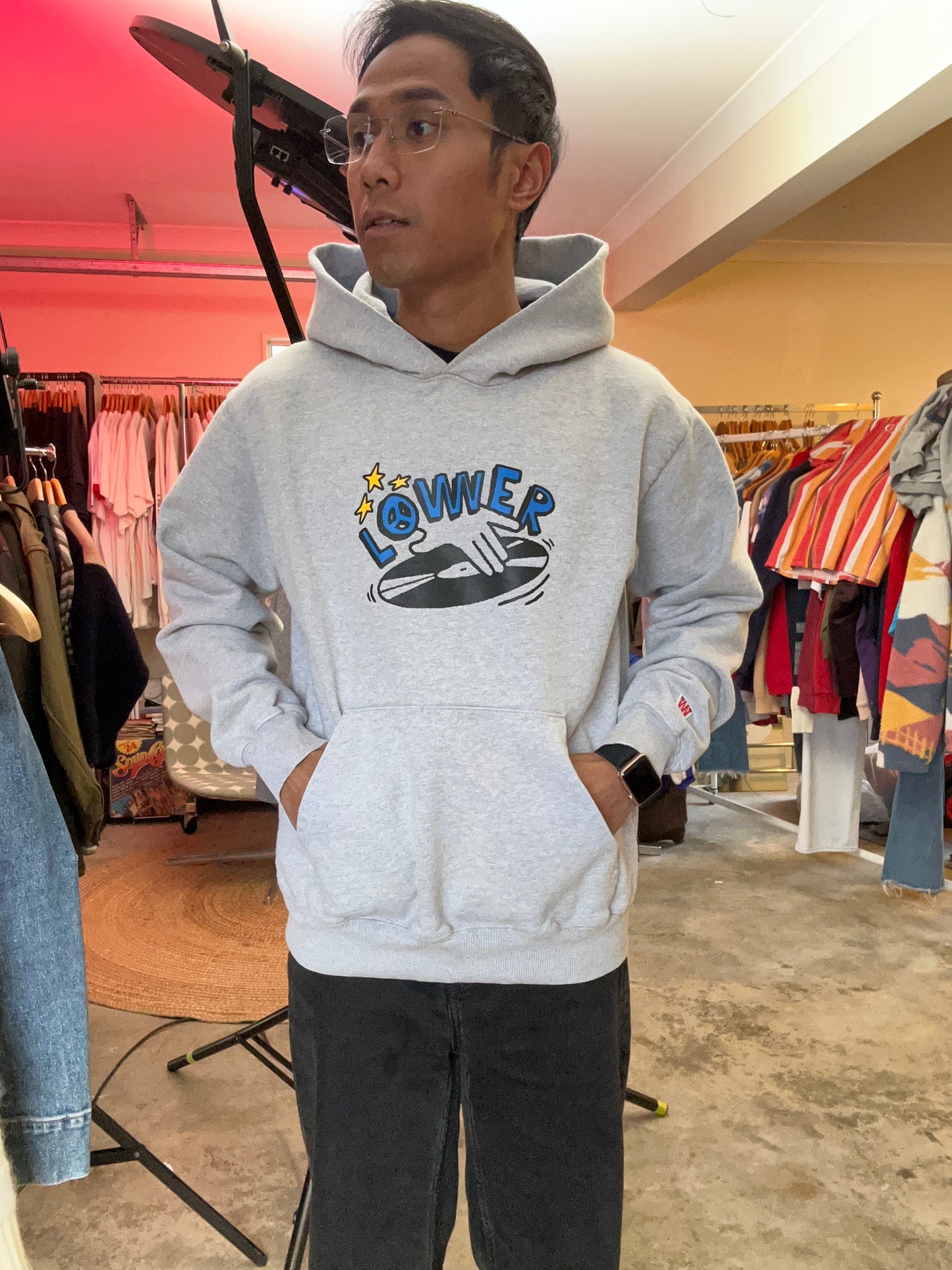 heather grey hoodie from Lower features a central "Lower" graphic of a hand on a vinyl record with star accents Medium